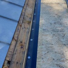 New rubber roof tie-in to existing standing seam roof in progress