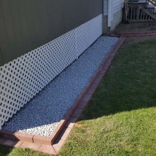 Landscaping project using crushed stone for drainage and bricks for borders